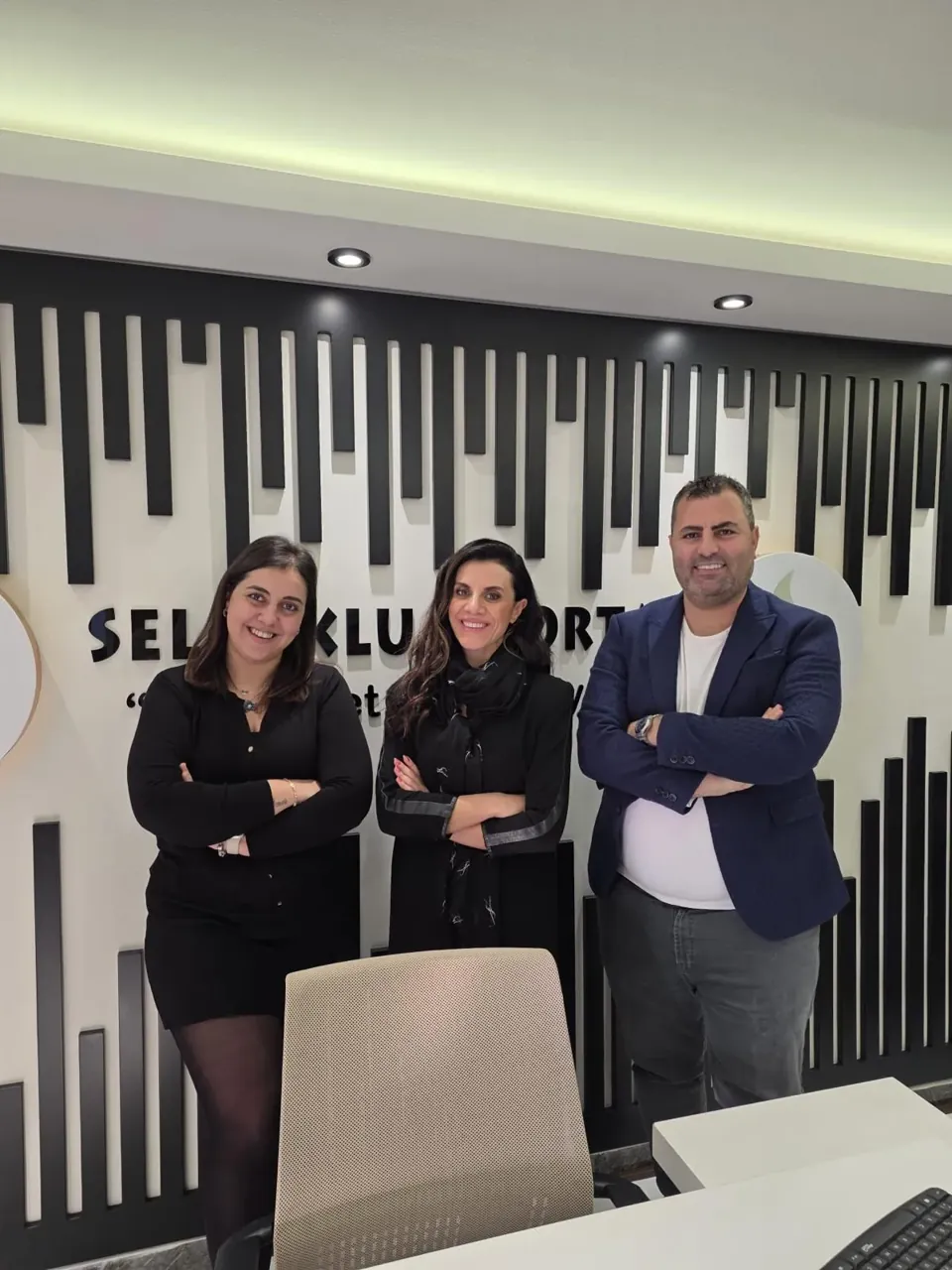 Selçuklu Sigorta ekibinden dört kişi logonun önünde